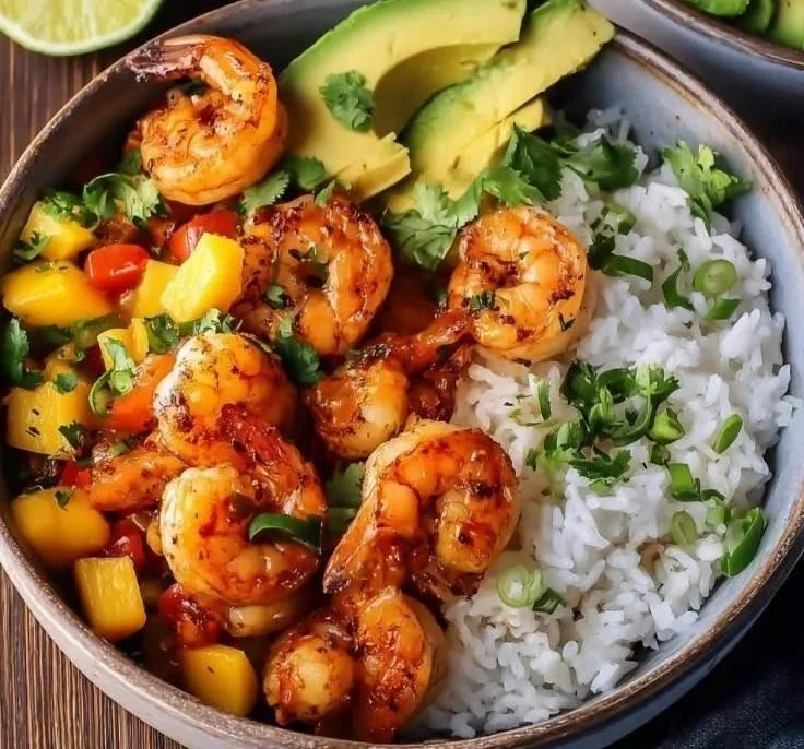 Delicious shrimp and rice bowl garnished with vegetables and herbs