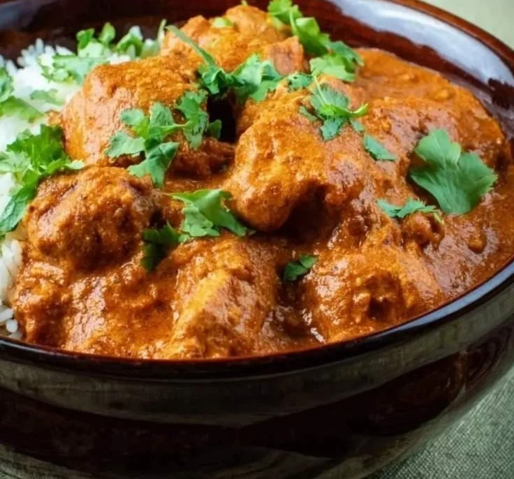 Delicious slow cooker chicken tikka masala served with rice and naan.