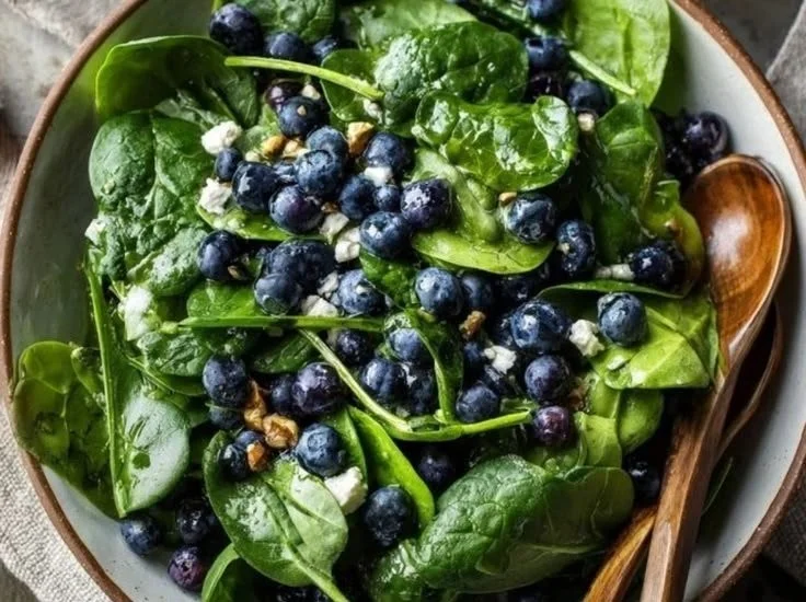 Fresh spinach blueberry salad with nuts and dressing